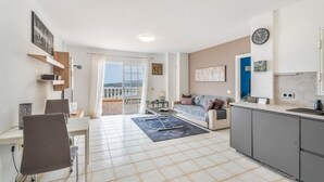 Eine moderne Wohnung mit Essbereich, Küche und Wohnbereich, mit einem Balkon und Blick.