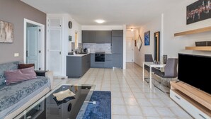Eine moderne Wohnung mit Wohnzimmer, Küche und Essbereich.