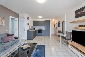 A modern apartment with a living room, kitchen, and dining area.