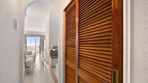 A hallway with a wooden door, a white wall, and a view of a balcony with a railing. - Vacation Home "Club Atlantis 223" with Sea View, Shared Pool & Wi-Fi (Adeje)