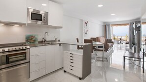 Eine moderne Küche mit eingebauter Mikrowelle, Backofen und einer kleinen Kochinsel mit Schubladen.