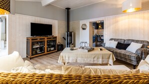 Una sala de estar con televisión, chimenea, sofá y comedor.