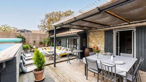 A patio with a pool, outdoor seating, and a covered dining area. - Stone House with Pool (vertheuil)