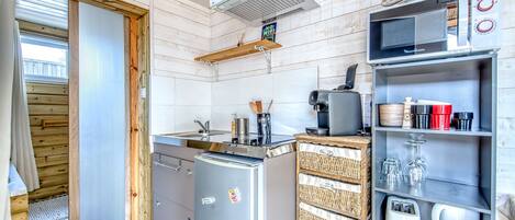 Cocina compacta con refrigerador, microondas y horno integrado.