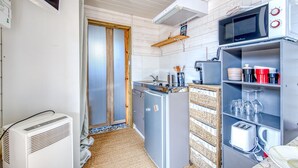 A compact kitchen with a microwave, toaster, and refrigerator.