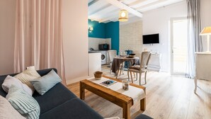 Ein Wohnzimmer mit Sofa, Couchtisch und einem Essbereich mit Stühlen und Tisch.