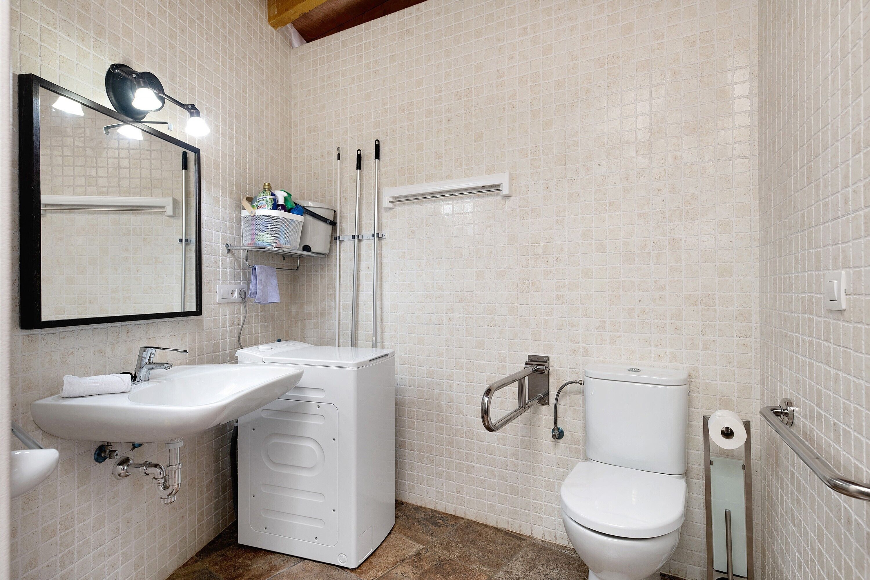 Une salle de bain équipée d’un lavabo, d’un miroir, de toilettes et d’un espace douche.