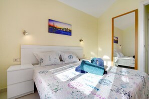 Una camera da letto con un letto, un comodino, una lampada da parete e un quadro.