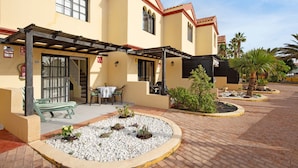 A building with a patio area, outdoor seating, and a small garden.