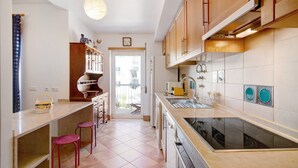 Una cocina moderna con una isla grande, armarios de madera y vistas al exterior.