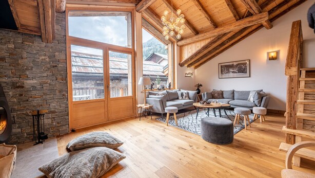 A cozy living room with a stone fireplace, wooden beams, a large window, and a modern sofa set. - Chalet "Alouette" with Private Terrace, 2 Balconies & Wi-Fi (Champagny-en-Vanoise)