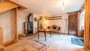 A cozy living room with a fireplace, wooden furniture, and a rustic decor. - Chalet "Alouette" with Private Terrace, 2 Balconies & Wi-Fi (Champagny-en-Vanoise)