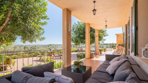 A covered outdoor seating area with a sofa, a table, and a view of the landscape. - Finca "Son Puca" with Mountain View, Pool & Wi-Fi (Petra)