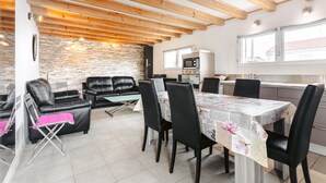 A dining area with a table, chairs, and a brick wall.