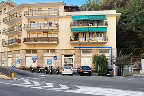 A multi-story building with balconies, a parking area with cars and motorcycles, and a sign indicating a nearby Eurospin casino. - Apartment "Casa Giovanna" with Private Terrace, Private Balcony & Wi-Fi (sanremo)