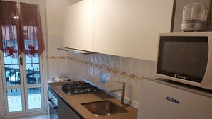 A kitchen with a microwave, sink, stove, and a refrigerator. - Apartment "Casa Giovanna" with Private Terrace, Private Balcony & Wi-Fi (sanremo)
