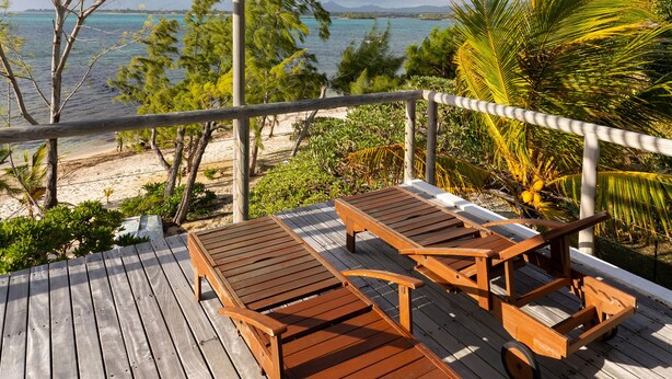 A wooden deck with a pergola, two wooden lounge chairs, and a cart. - Koki Bonheur by muse villas (Poste Lafayette)
