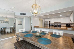 A modern kitchen with white cabinets, a stainless steel refrigerator, and a built-in oven.