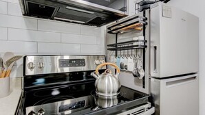 Una cocina con estufa de acero inoxidable, hervidor y horno empotrado.