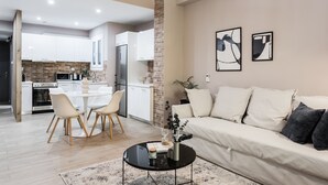 A modern living room with a sofa, coffee table, and artwork on the wall. - Gorgeous 1BR Apartment in Kolonaki (Athens)