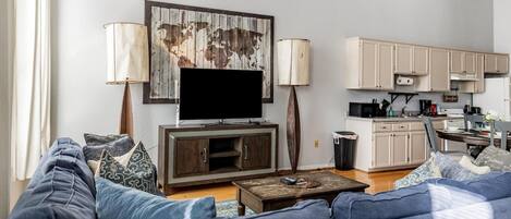 A living room with a sofa, a coffee table, a TV, and a world map artwork.