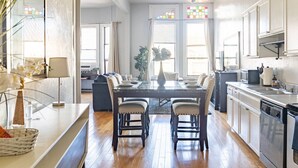 A spacious kitchen with a dining area, large windows, and a view of the city. - Spacious 1 BR 700 sq ft loft suite with free parking, steps to the Convention Center and Gaslamp dining.  Ideal for business or group travel. (San Diego)