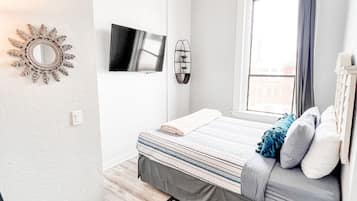 2 habitaciones, escritorio y tabla de planchar con plancha