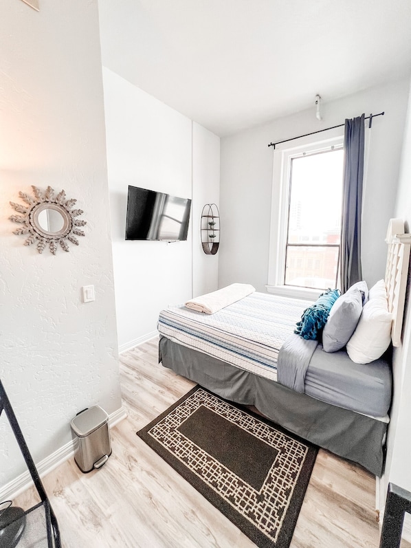 2 habitaciones, escritorio y tabla de planchar con plancha
