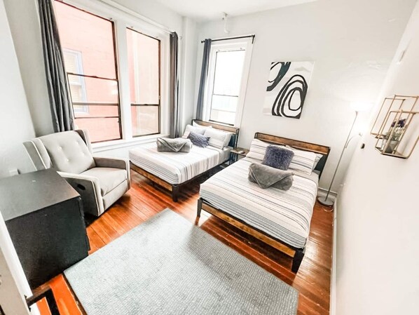 2 habitaciones, escritorio y tabla de planchar con plancha