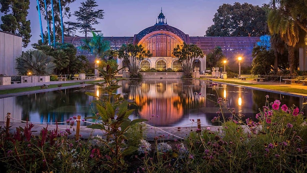 Ein friedlicher Garten mit einem Teich, einem Gazebo und einem Gebäude mit Kuppel.