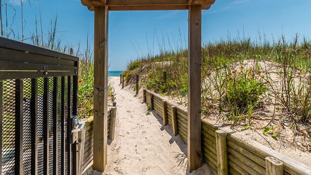 A wooden pathway leading to a beach with a clear view of the ocean. - Beautiful 2BR/2BA ocean view condo that feels like home (Wrightsville Beach)