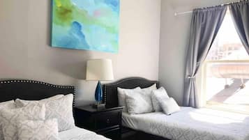 2 habitaciones, escritorio y tabla de planchar con plancha