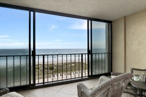 Uma varanda com vista para a praia e o oceano.