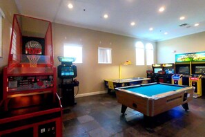 Sala de recreación con mesa de billar, aro de baloncesto y juegos de arcade.