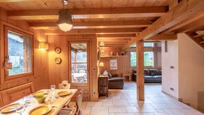 A wooden interior with a dining area, a sofa, and a staircase. - Family chalet with terrace and garden in Chamonix (Chamonix-Mont-Blanc)