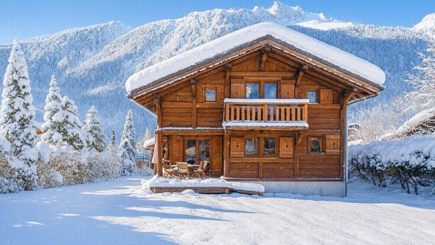 A wooden chalet with a balcony, surrounded by snow-covered trees and mountains. - Family chalet with terrace and garden in Chamonix (Chamonix-Mont-Blanc)