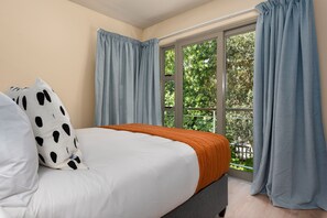 A bedroom with a bed, a window, and curtains. - Luxe 2-Bed in Trendy Green Point , Pool Views (Cape Town)