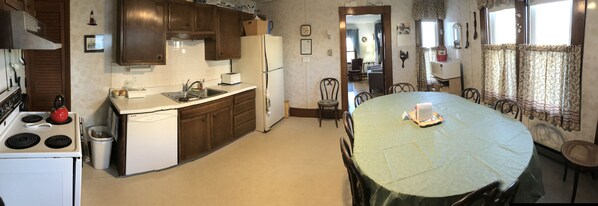 A compact kitchen with a dining area, a stove, a sink, and a refrigerator. - York Manor, Apt 2, Short Sands Beach (York)