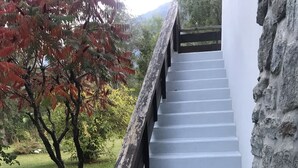 A staircase with white steps leading up to a wooden railing, surrounded by greenery and a stone wall. - Bourg d'Oisans, a cyclist's paradise (Le Bourg-d'Oisans)
