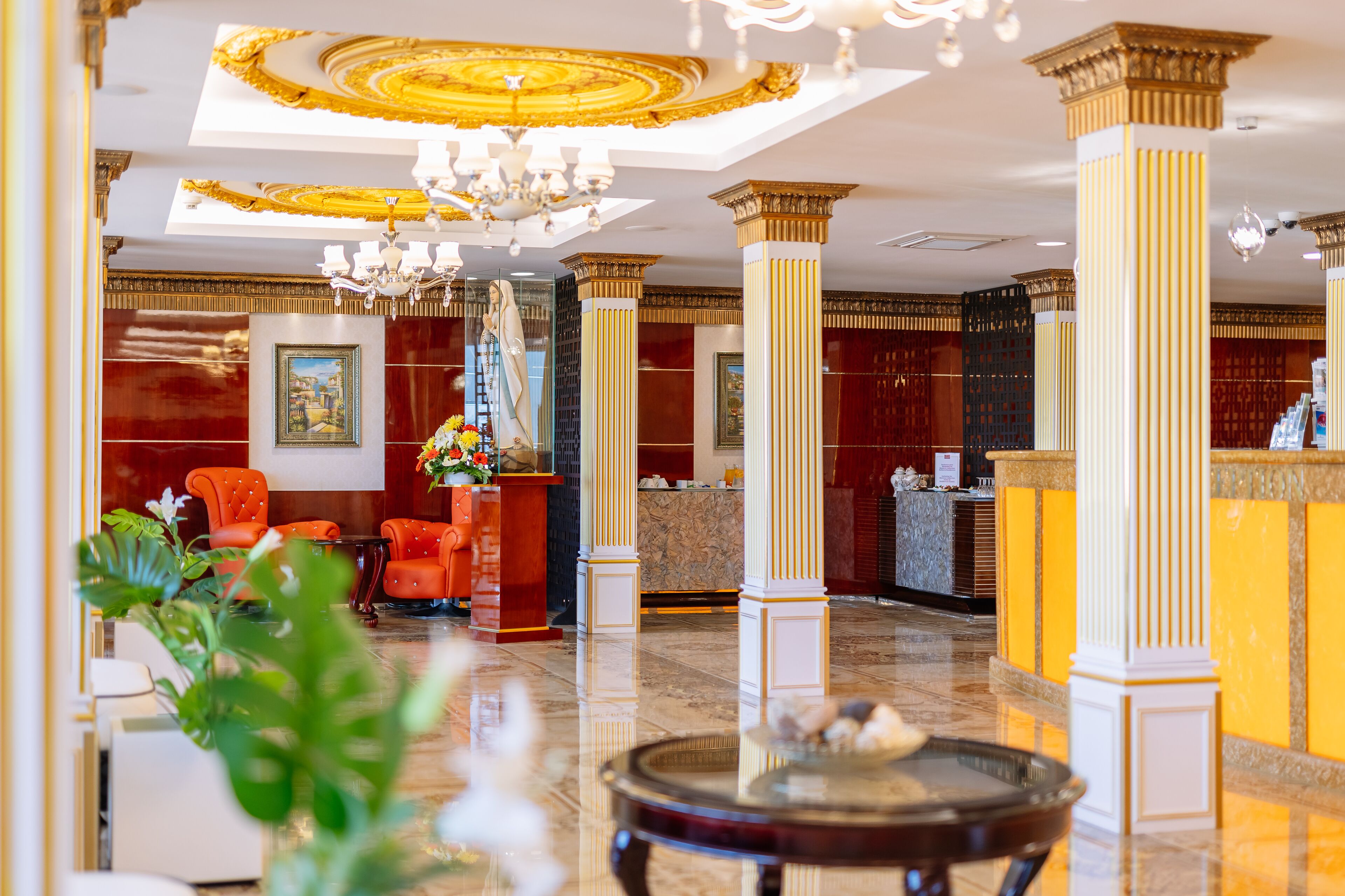 A lobby with marble flooring, a reception desk, and a chandelier.