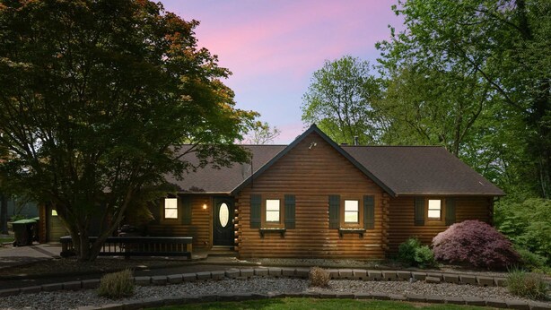 A log cabin with a front porch, a small garden, and a bench. - Lakefront Family Retreat • Dock • Hot Tub & Games (Cadiz)