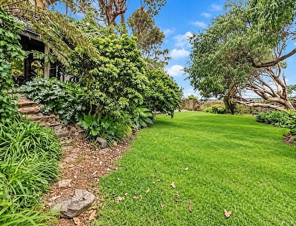 A well-maintained garden with a variety of plants and a lawn.