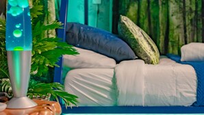 A bunk bed with a blue and white color scheme, a lava lamp, and a green plant.