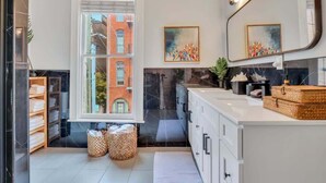 Un baño moderno con un ventanal grande, una chimenea y un espejo con iluminación.