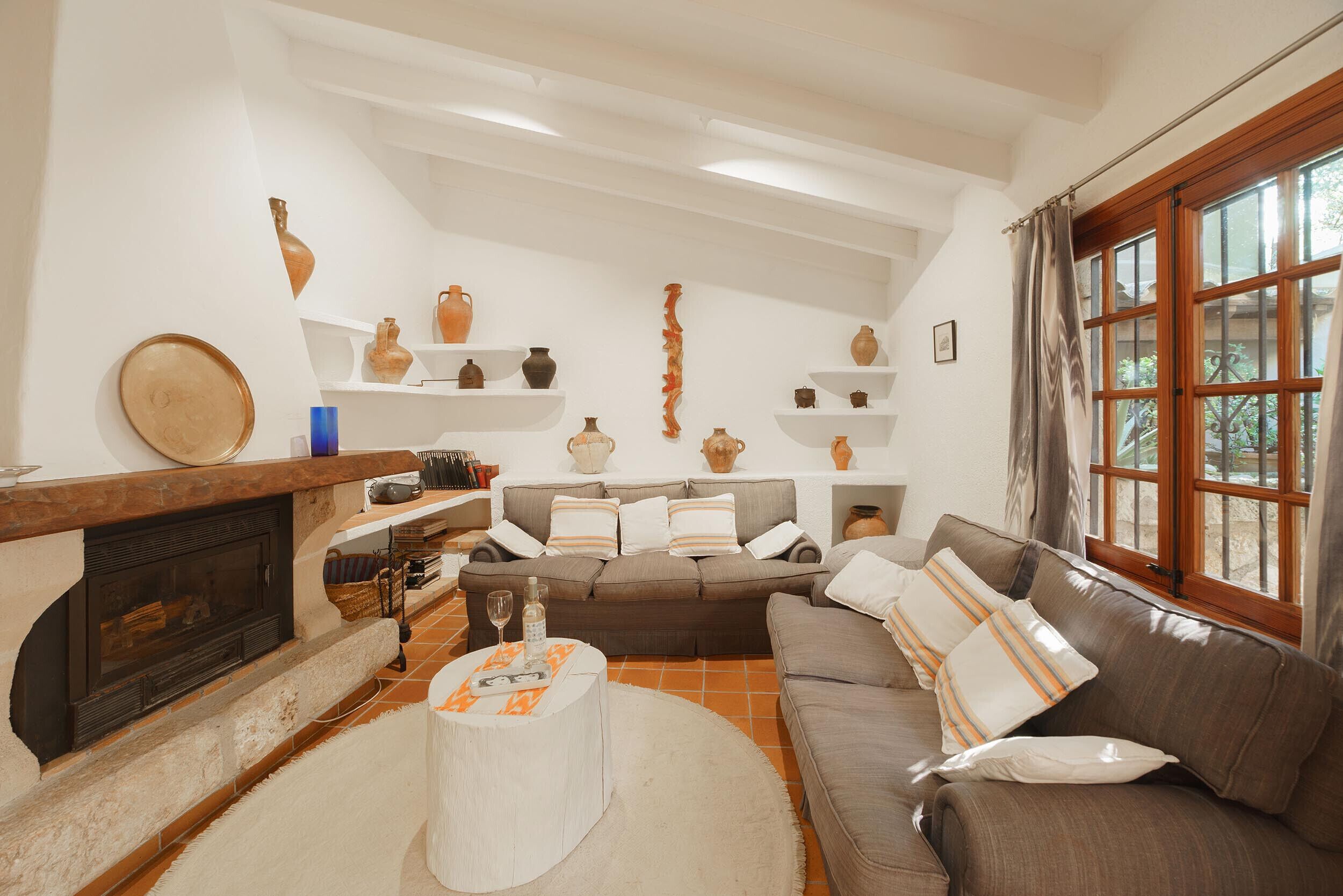 Ein Wohnzimmer mit Kamin, einer Couch, einem Couchtisch und Regalen mit Dekoration.