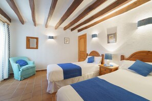 A room with two beds, a chair, and a wooden ceiling. - Townhouse Calvario at Calvari (Pollensa / Pollença)