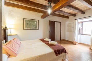 A bedroom with a bed, a map on the wall, a wooden ceiling, and a window. - Holiday Rental Can Colonya in Majorca Ternelles (Pollensa / Pollença)