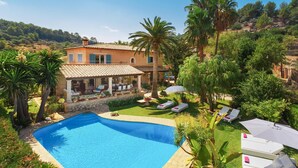 A villa with a swimming pool, outdoor seating, and lush greenery. - Majorca Villa with pool in Majorca - Villa Font (Mancor de la Vall)