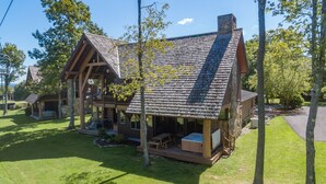 A rustic cabin with a porch, a hot tub, and a deck. - Mountain Top Ski In/Out Chalet w/ Hot Tub (McHenry)