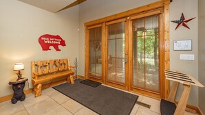 A reception area with a wooden bench, a bear-shaped welcome sign, a star decoration, and a wooden chair. - Mountain Top Ski In/Out Chalet w/ Hot Tub (McHenry)
